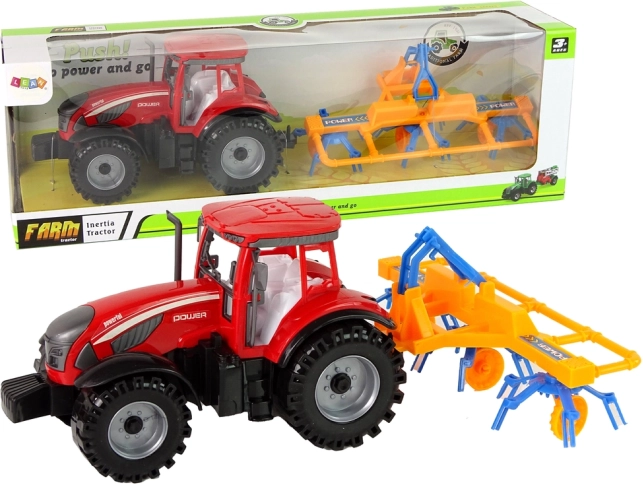 Červený traktor so zhrabovačom s frikčným pohonom