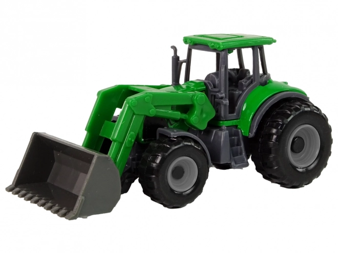 Malý zelený traktor s radlicou