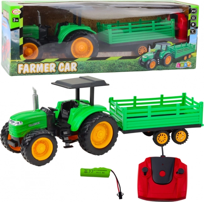 Zelený diaľkovo ovládaný farmársky traktor s prívesom