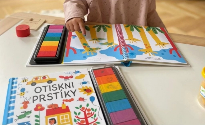 Otlačky prstov s knihou Svojtka & Co.